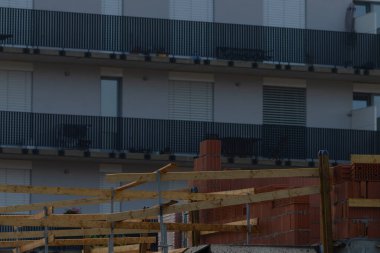A modern apartment buildings construction site showcases balconies and scaffolding, highlighting urban development.