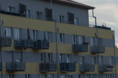 Contemporary apartment building features multiple balconies and air conditioning units, showcasing urban living in a modern setting.