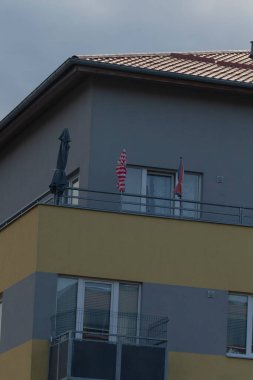 A picturesque view of two flags displayed on a balcony, highlighting urban living. The flags add character to the modern architecture.