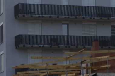 View of modern apartment balconies under construction, showcasing building materials and architecture. A blend of residential living and urban development.