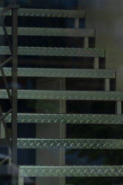 Endüstriyel ve mimari temalar için ideal desenli basamakları gösteren metal spiral bir merdivenin yakın çekimi.