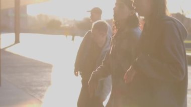 A video shows diverse people enjoying a sunny day in a park, capturing moments of connection, laughter, and outdoor socializing