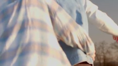 This video shows a vibrant social gathering with dance and conversation. A woman in plaid chats with a man in denim as another dances