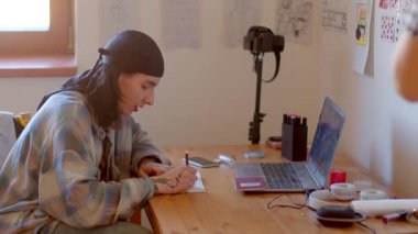 The video showcases individuals at desks a man on a laptop, a young man with a notebook, and two women working on laptops and a camera, highlighting productivity