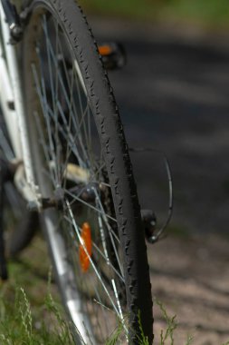 Bisiklet lastiğinin yakın plan görüntüsü, çakıllı bir yolda lastik izlerini gösteriyor, bisiklet ve doğa arasındaki bağlantıyı vurguluyor..