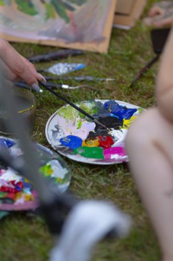 A close-up of a painters palette filled with vibrant colors, capturing the essence of creativity in a natural outdoor setting.