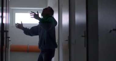 A shadowy figure moves cautiously down a dimly lit hallway, creating suspense and intrigue. Perfect for thriller or mystery themes.