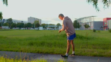 Experience a vibrant park as a young man skates energetically along a scenic path, balancing activity and relaxation in this engaging portrayal