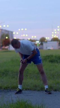 An energetic man in blue shorts showcases his fitness routine by jumping rope in a vibrant field and serene park at night, emphasizing dedication