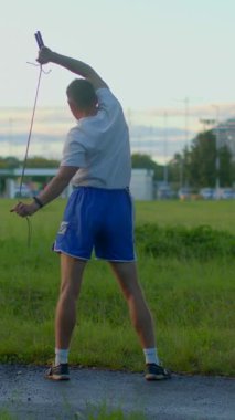A dedicated young athlete is training intensely with a sword in a grassy area, performing dynamic poses to enhance skills for an important sworddrawing exercise upcoming