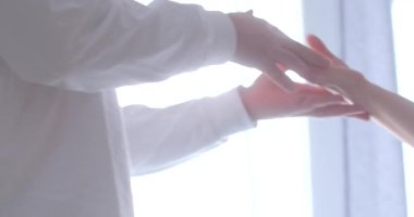 A serene scene capturing the gentle touch of two hands reaching towards each other, symbolizing connection and warmth in a soft-lit environment.