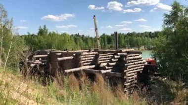 Bir kütükten ev inşa etmek. Bir grup adam bir vakfa kütük ev kuruyor..