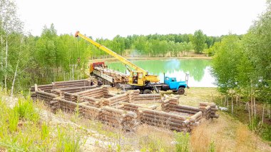 Bir kütükten ev inşa etmek. Bir grup adam bir vakfa kütük ev kuruyor..