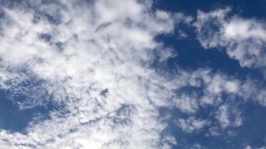 Kümülüs bulutları açık mavi gökyüzünde. Zaman Ayarı 4k videosu.