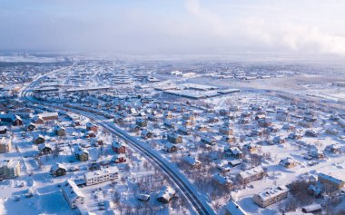 İsveç 'in en kuzeyindeki şehir olan Kiruna' nın kış manzarası. Kışın insansız hava aracından çekilmiş güneşli bir görüntü.