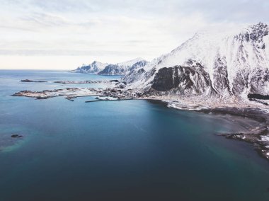 Aerial winter view of Lofoten Islands, Nordland, Norway, with fjord, road, bridge and mountains, shot from drone clipart