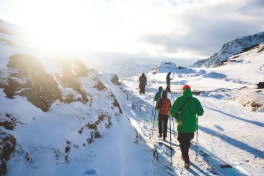 Ryten dağ ve Kvalvika beach, yürüyüşçüler ve dağların etrafında, güneşli kış günü grupları ile giderken Kuzey Norveç, Lofoten Adaları, Nordland, dağ manzarası görünümünü