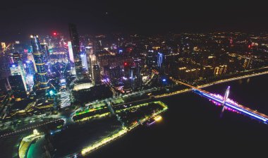 Beautiful wide-angle night aerial view of Guangzhou Zhujiang New Town financial district, Guangdong, China with skyline and scenery beyond the city, seen from the observation deck of Canton Tower clipart