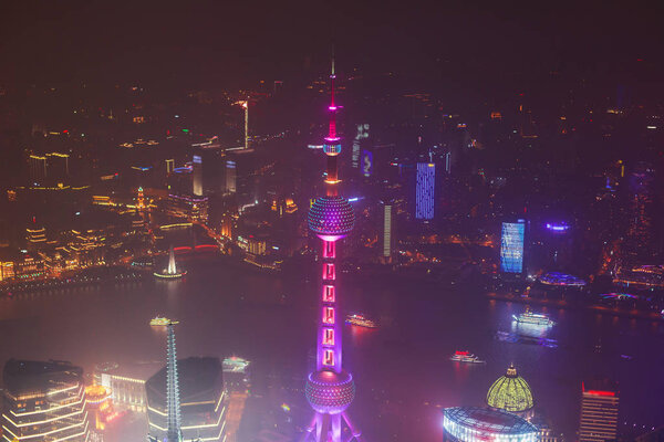 Beautiful super wide-angle night aerial view of Shanghai, China with Pudong district, TV tower, the Bund and scenery beyond the city, seen from the observation deck of Shanghai World Financial Cente
