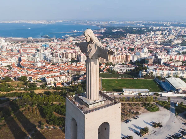 View of The Sanctuary of Christ the King, Cristo Rei, Almada, Lisbon, with 25 de Abril Bridge suspension Bridge, Tagus river, aerial drone view in summer sunny da