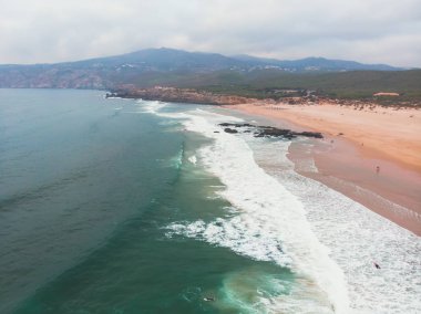 Praia görünümünü do Guincho, Guincho beach, popüler Atlantik Okyanusu plaj Portekiz'in Estoril kıyısında, Cascais, Belediyesi ile dalgaların sörf sörfçü dron vurdu