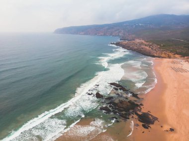 Praia görünümünü do Guincho, Guincho beach, popüler Atlantik Okyanusu plaj Portekiz'in Estoril kıyısında, Cascais, Belediyesi ile dalgaların sörf sörfçü dron vurdu