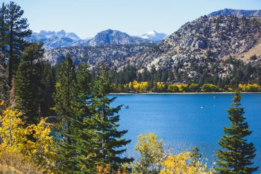 Beautiful vibrant panoramic view of June Lake, Mono County, California, with Mountains of Sierra Nevada and Carson Peak in the background, United State clipart