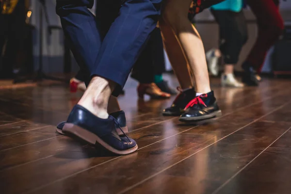 Dancing shoes of young couple dance retro jazz swing dances on a ballroom club wooden floor, close up view of shoes, female and male, dance lessons