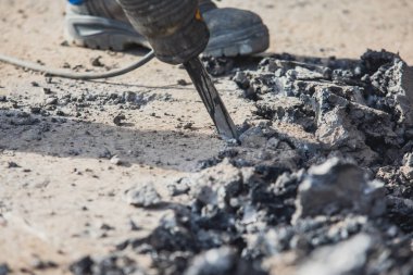 Yol onarımı, matkap, pnömatik çekiç ve matkap ile inşaat işçisi inşaat alanında asfalt kaldırım ve beton kırma ekipmanları ile çalışır.