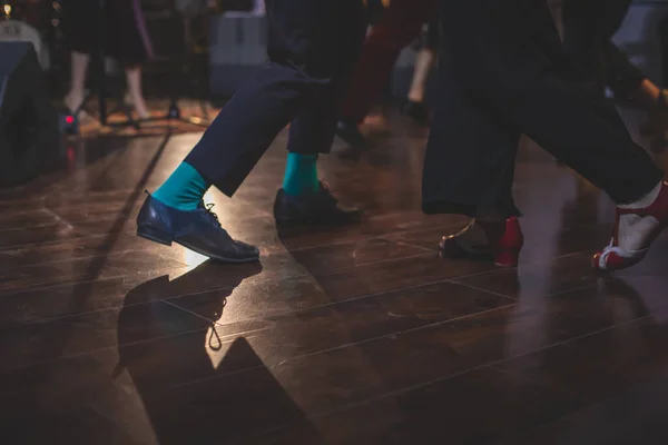 Dancing shoes of young couple dance retro jazz swing dances on a ballroom club wooden floor, close up view of shoes, female and male, dance lessons