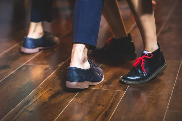 Dancing shoes of young couple dance retro jazz swing dances on a ballroom club wooden floor, close up view of shoes, female and male, dance lessons