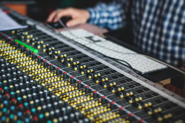 Sound editor engineer working at studio with mixing panel, mixing music and sound, stage sound mixer, boutique recording studio, working during concert performance recording, broadcasting studio