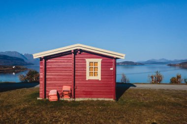 Geleneksel ahşap kırmızı kulübeleriyle klasik Norveç kamp alanı manzarası, Kuzey Norwa