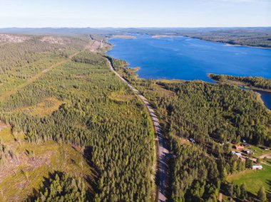 Kalix nehri, Kalixalven, Overkalix yerleşim yeri ve İsveç 'in Norrbotten ilçesinde güneşli yaz günlerinde ormanlık alan, hava aracı manzarası
