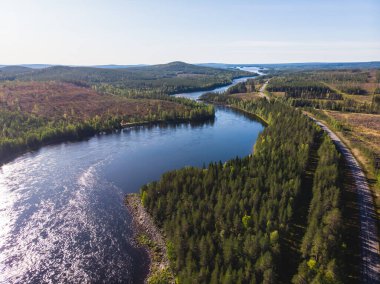 Kalix nehri, Kalixalven, Overkalix yerleşim yeri ve İsveç 'in Norrbotten ilçesinde güneşli yaz günlerinde ormanlık alan, hava aracı manzarası