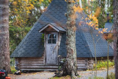 Finnish Ulusal Parkı manzarası: Ahşap kulübe, kulübe kulübesi, ahşap asma köprü, ahşap merdiven basamakları, kamp alanı, masa, ateş çukuru, bank ve Oulanka, Lapland, Finlandiya