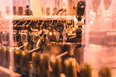 Taşıma bandındaki cam şişelerin görüntüsü, üretim hattındaki şişe boyunları, bira fabrikası ekipmanları, şarap fabrikasının içi, alkol üretimi süreci...