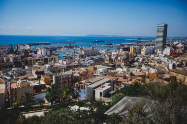 Alicante, Valencia Topluluğu 'nun güzel geniş hava manzarası, İspanya' nın Alicante limanı, plaj ve marinası, dağları ve gökdelenleri, güneşli bir günde Benacantil Dağı 'ndaki Santa Barbara Kalesi' nden görülüyor.