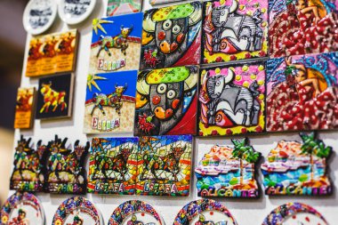 İspanya, Alicante, Valencia 'dan geleneksel turist hatıraları ve hediyeleri oyuncakları, boğa figürleri flamenko dansçı bebekleri, buzdolabı mıknatısları ve anahtarlık anahtarlıkları yerel hediyelik eşya dükkanında.