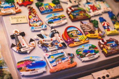 İspanya, Alicante, Valencia 'dan geleneksel turist hatıraları ve hediyeleri oyuncakları, boğa figürleri flamenko dansçı bebekleri, buzdolabı mıknatısları ve anahtarlık anahtarlıkları yerel hediyelik eşya dükkanında.