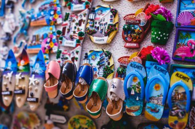 İspanya, Alicante, Valencia 'dan geleneksel turist hatıraları ve hediyeleri oyuncakları, boğa figürleri flamenko dansçı bebekleri, buzdolabı mıknatısları ve anahtarlık anahtarlıkları yerel hediyelik eşya dükkanında.