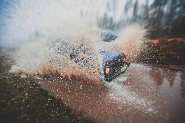 越野4Wd车骑通过泥泞的水坑 越野的轨道道路 与一个巨大的水花 在一个吉普车竞赛 — 图库照片