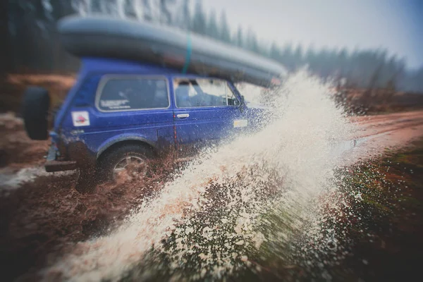 越野4Wd车骑通过泥泞的水坑 越野的轨道道路 与一个巨大的水花 在一个吉普车竞赛 — 图库照片