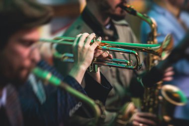 Bir erkek trompetçinin konser görüntüsü, profesyonel trompetçi, caz grubu performansı sırasında vokalist ve müzikal.