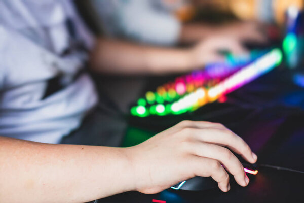 Cyber sport e-sports tournament, team of professional gamers, close-up on gamer's hands on a keyboard, pushing button, gamers playing in competitive moba/strategy fps game on a cyber games arena club