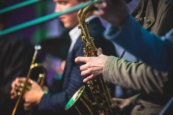 Concert view of a saxophonist, saxophone sax player with vocalist and musical during jazz orchestra performing music on stage