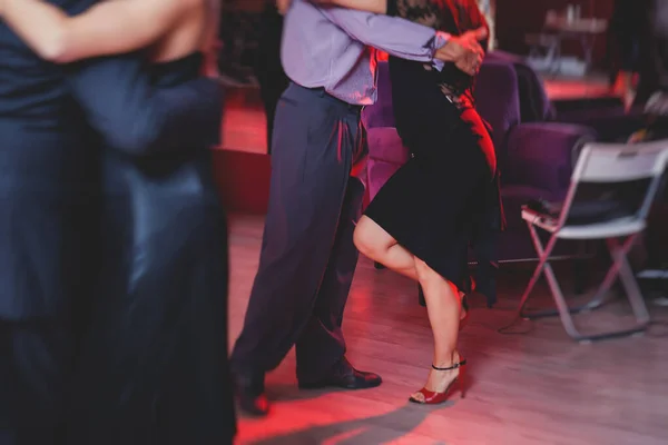 情侣们在舞厅里跳着千禧舞 在红灯下跳着探戈课 在舞会上跳着舞 — 图库照片