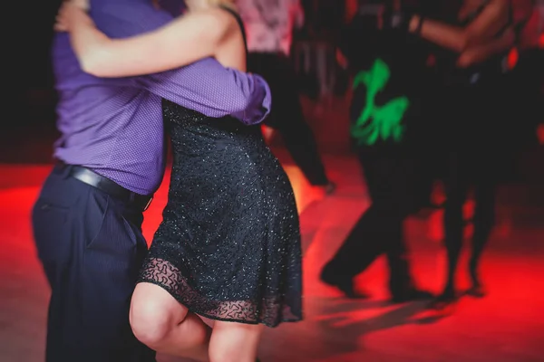 情侣们在舞厅里跳着千禧舞 在红灯下跳着探戈课 在舞会上跳着舞 — 图库照片
