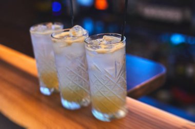 Bir partide, martinide, votkada ve diğerlerinde, açık hava etkinliğinde, arka planda barmen olan dekore edilmiş yemek masasında güzel renkli alkollü kokteyller.