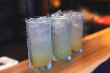 Bir partide, martinide, votkada ve diğerlerinde, açık hava etkinliğinde, arka planda barmen olan dekore edilmiş yemek masasında güzel renkli alkollü kokteyller.